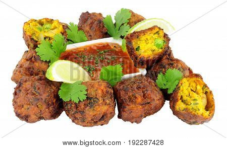 Group of fried vegetable pakora with chilli sauce dip isolated on a white background