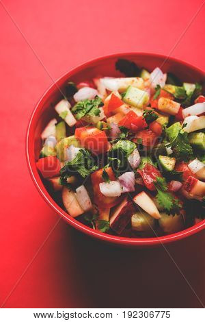Indian Green Salad also known as Kachumber is a colourful salad dish in Indian cuisine consisting of fresh chopped tomatoes, cucumbers, onions, and sometimes, chili peppers. selective focus