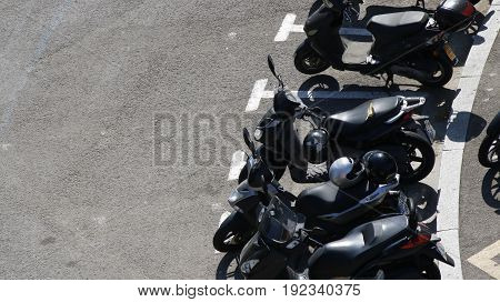 Scooters parked on an asphalt road in special parking spots Spain July 2016