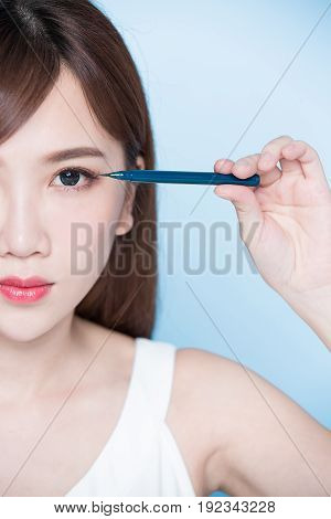 beauty woman woman take eyeliner on the blue background