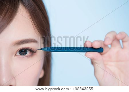 beauty woman woman take eyeliner on the blue background