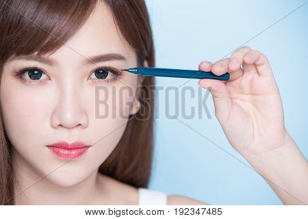 beauty woman woman take eyeliner on the blue background