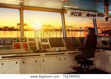 wheelhouse control board of modern industry ship approaching to harbor at night