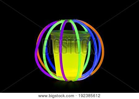 Yellow fluorescent glass in ball with glow sticks neon light on back background. variation of different colored chem lights