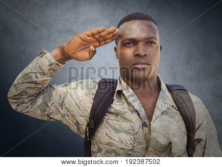 Digital composite of Soldier saluting against navy background with grunge overlay
