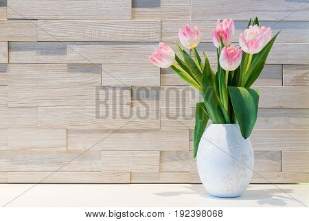 Beautiful bouquet of fresh tulips flowers against modern brick wall background.