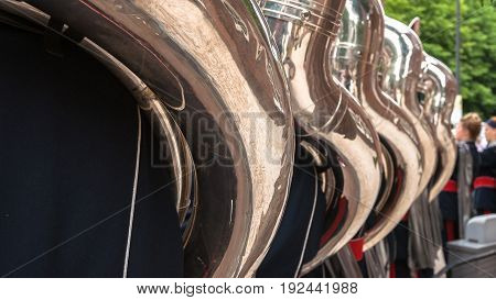Details from a music show and marching band. Playing musicians wind instruments in uniforms. Tuba Sousa