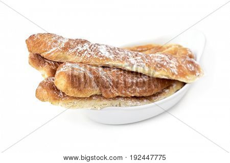 closeup of some fartons, typical pastries of Valencia, Spain, in a white ceramic bowl on a white background