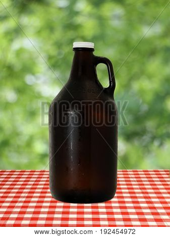 Growler at on Red Checkered Tablecloth against Blurry Trees