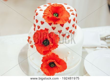 beautiful wedding cake with red poppies and hearts
