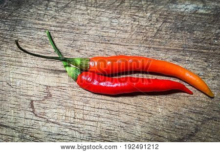 red and orange chillis on old wood background