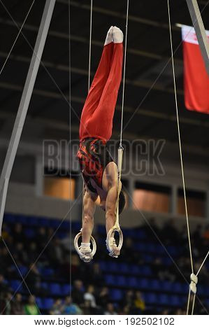 Male Gymnast Performing On Stationary Gymnastic Rings
