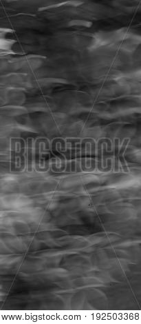 This is a black and white close up of a chain saw pattern created on a wooden log.