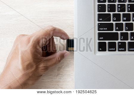 hand inserting memory card into laptop slot