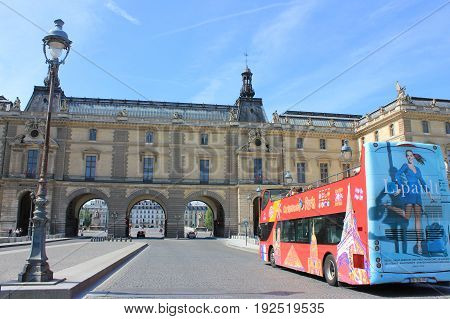 PARIS, FRANCE - JUNE 5, 2017: Hop on Hop off red tourist tour bus in front of Louvre museum. The bus helps tourists to visit all popular travel landmark and attractions in the city of Paris, most visited city in Europe.
