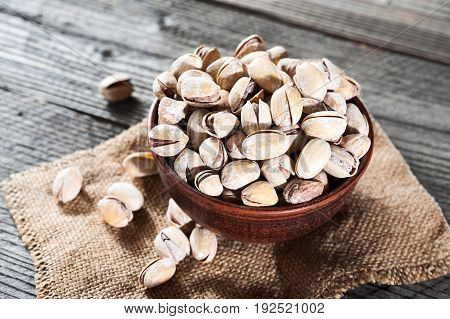 Pistachios In Wooden Bowl Over Wooden Background, Selective Focus.