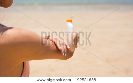 Girl Applying Sun Lotion On The Beach