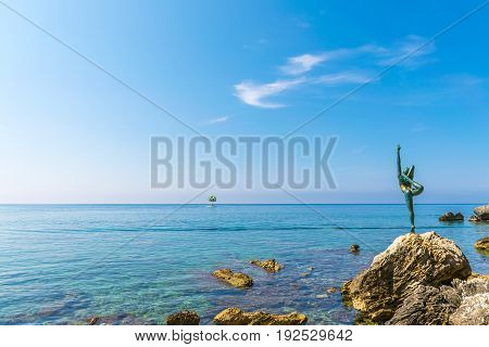 On the shore of the Adriatic Sea is a statue of a ballerina. Budva Mogren beach.