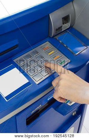 Hand of a woman using an ATM. Woman using an atm machine pressing her password.