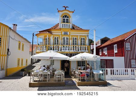 Costa Nova Portugal - June 09 2017: Famous resort on the Atlantic coast in Beira Litoral Portugal. Popular tourist destination to spend vacation time. Tourists has a dinner in restaurant