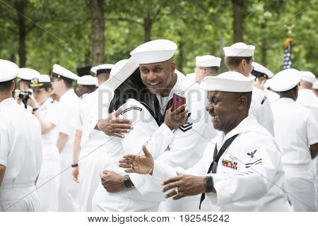 Participating U.S. Navy sailors hug and congratulate each other after the re-enlistment and promotion ceremony at the National September 11 Memorial site. Fleet Week, NEW YORK MAY 26 2017