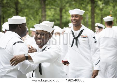 Participating U.S. Navy sailors hug and congratulate each other after the re-enlistment and promotion ceremony at the National September 11 Memorial site. Fleet Week, NEW YORK MAY 26 2017