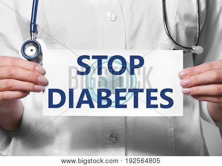 Health care concept. Doctor holding paper with text STOP DIABETES, closeup