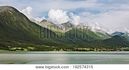Panoramic view of the mountains along the Romsdalsfjorden in Norway under a sunny sky