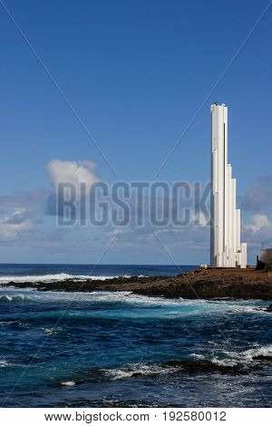 The lighthouse towering punta del hidalgo while foam forms on the waves