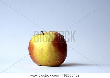 Ripped apple with waterdrops in a white background