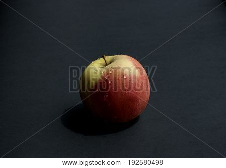 Ripped apple with waterdrops in a black  background