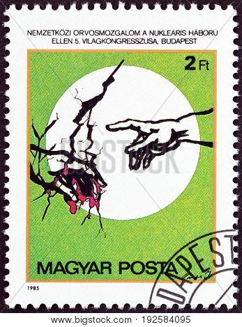 HUNGARY - CIRCA 1985: A stamp printed in Hungary issued for the 5th Congress of International Association of Physicians against Nuclear War, Budapest shows Hand pointing to Cracked Earth, circa 1985.