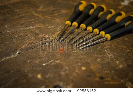 Set of torx screwdrivers with rubber handles on top of an old wooden workbench.
