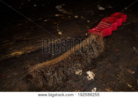 Old worn wire bruch on an old wooden workbench