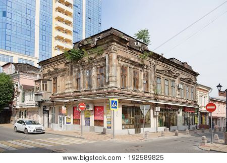 Rostov-on-Don Russia - June 182017: Ancient house with seedling trees at the intersection of the lane Semashko and street Serafimovich.The streets are pedestrian and the car is moving