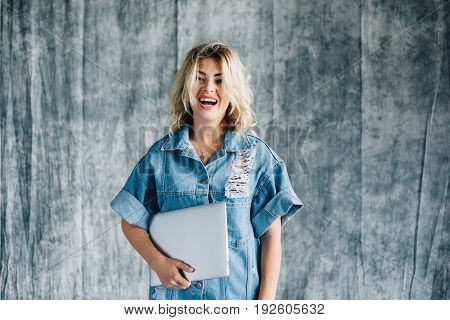 Lovely pretty girl with a laptop smiling and happy that she did the work on time