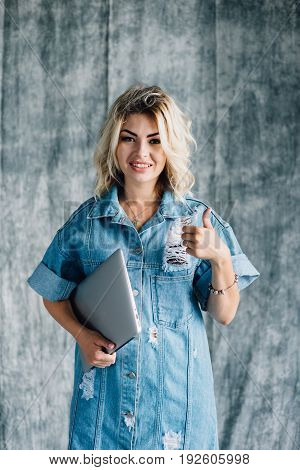 Lovely pretty girl with a laptop smiling and happy that she did the work on time