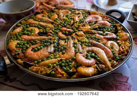 Seafood paella in a frying pan is on the table