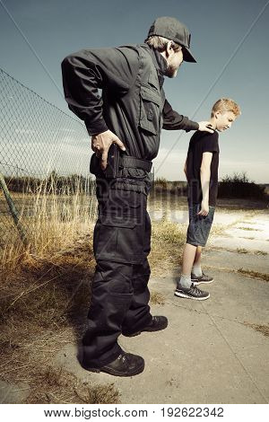Police man catching teenage boy pickpocket outdoor