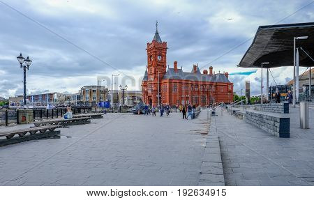 Cardiff Bay Cardiff Wales - May 20 2017: Sinedd National Assembly building and Pierhead builidng. Shows wide walkway with people.