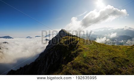 High mountain ridge hidden in clouds during sunrise, Koschuta, Slovenia