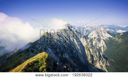 High mountain ridge hidden in clouds during sunrise, Koschuta, Slovenia