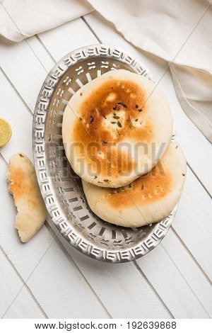 Kulcha is a type of leavened bread originated from the Indian Subcontinent; eaten in India and Pakistan, made from maida. Selective focus. Isolated