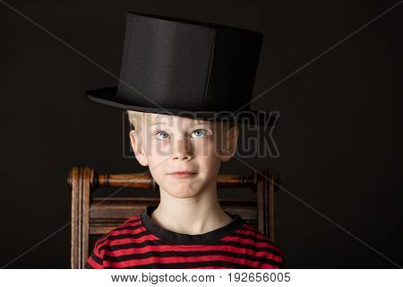 Charismatic Little Boy Wearing An Out Size Top Hat