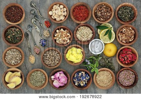 Healthy herb tea selection in wooden bowls and old spoons and strainer, teas also used in alternative medicine.