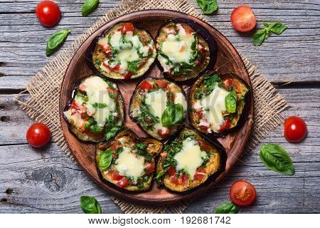 Mini pizza with eggplant tomato and basil . Top view