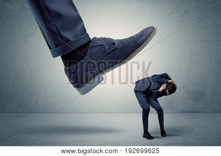 Demoralised employee symbolized by small man getting trampled