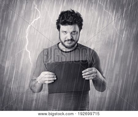Caught gangster with rainy, grey background and black table on his hand. 