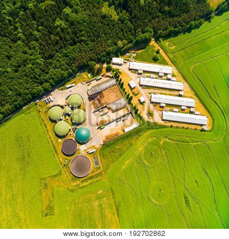 Aerial view over biogas plant and farm in green fields. Renewable energy from biomass. Modern agriculture in Czech Republic and European Union. 