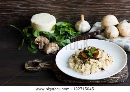 Risotto With Mushrooms On A Dark Wooden Background